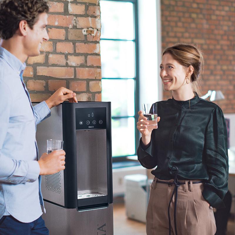 Personas hablando al lado de un dispensador de agua